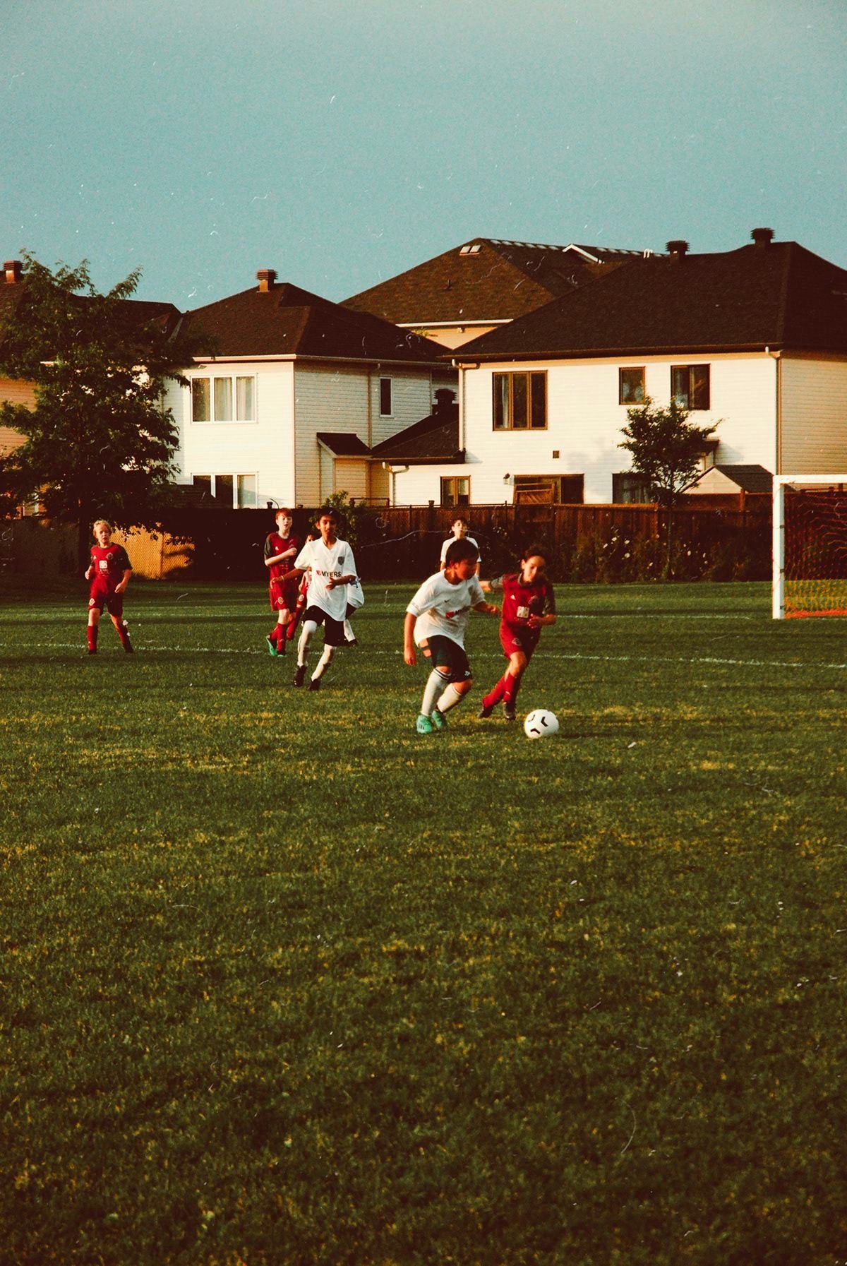 Children playing a neighborhood soccer game at golden hour